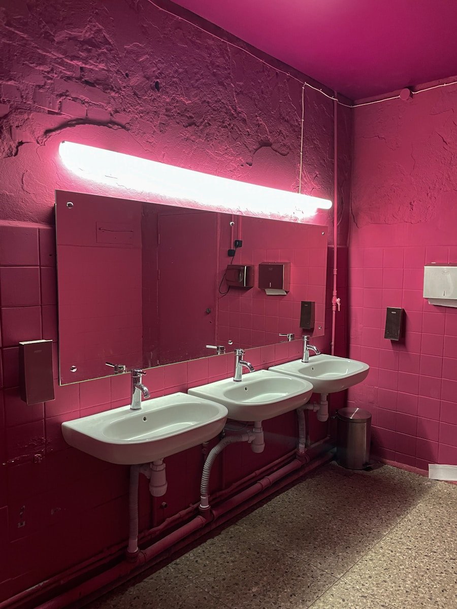 a pink bathroom with two sinks and a mirror